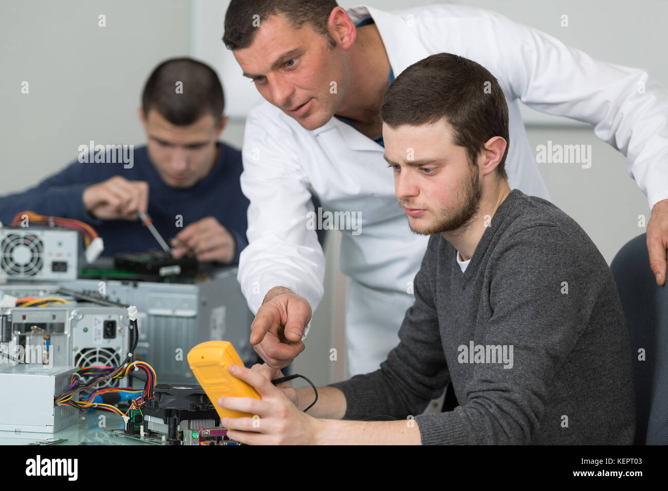 teacher guiding student on how to use multimeter Stock Photo - Alamy