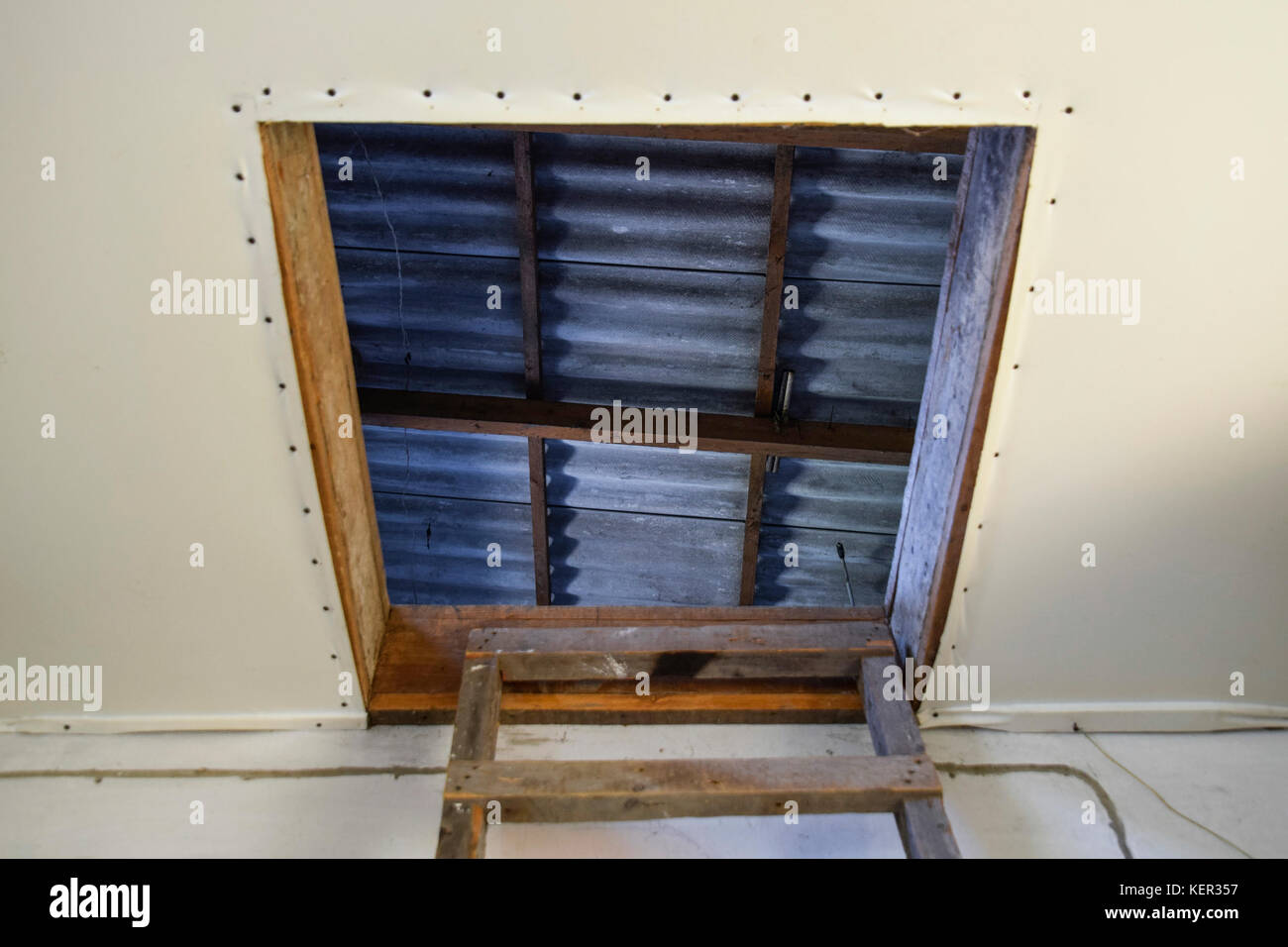 Open the entrance to the attic. The staircase and the door to the attic of the house Stock Photo