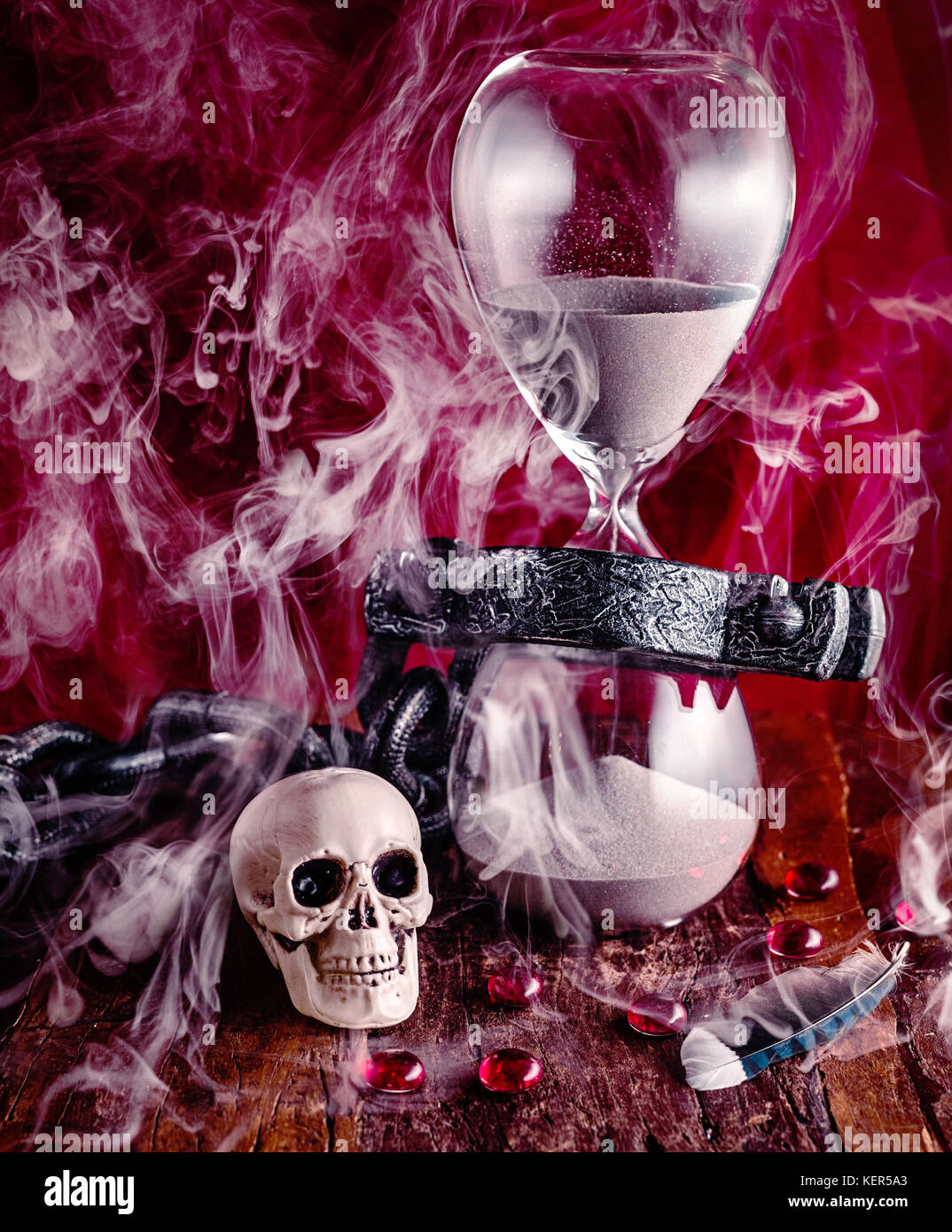 Time is like smoke in the wind, light as a feather and fleeting.   Yet, we are chained to it as the sand falls through the hour glass until death take Stock Photo