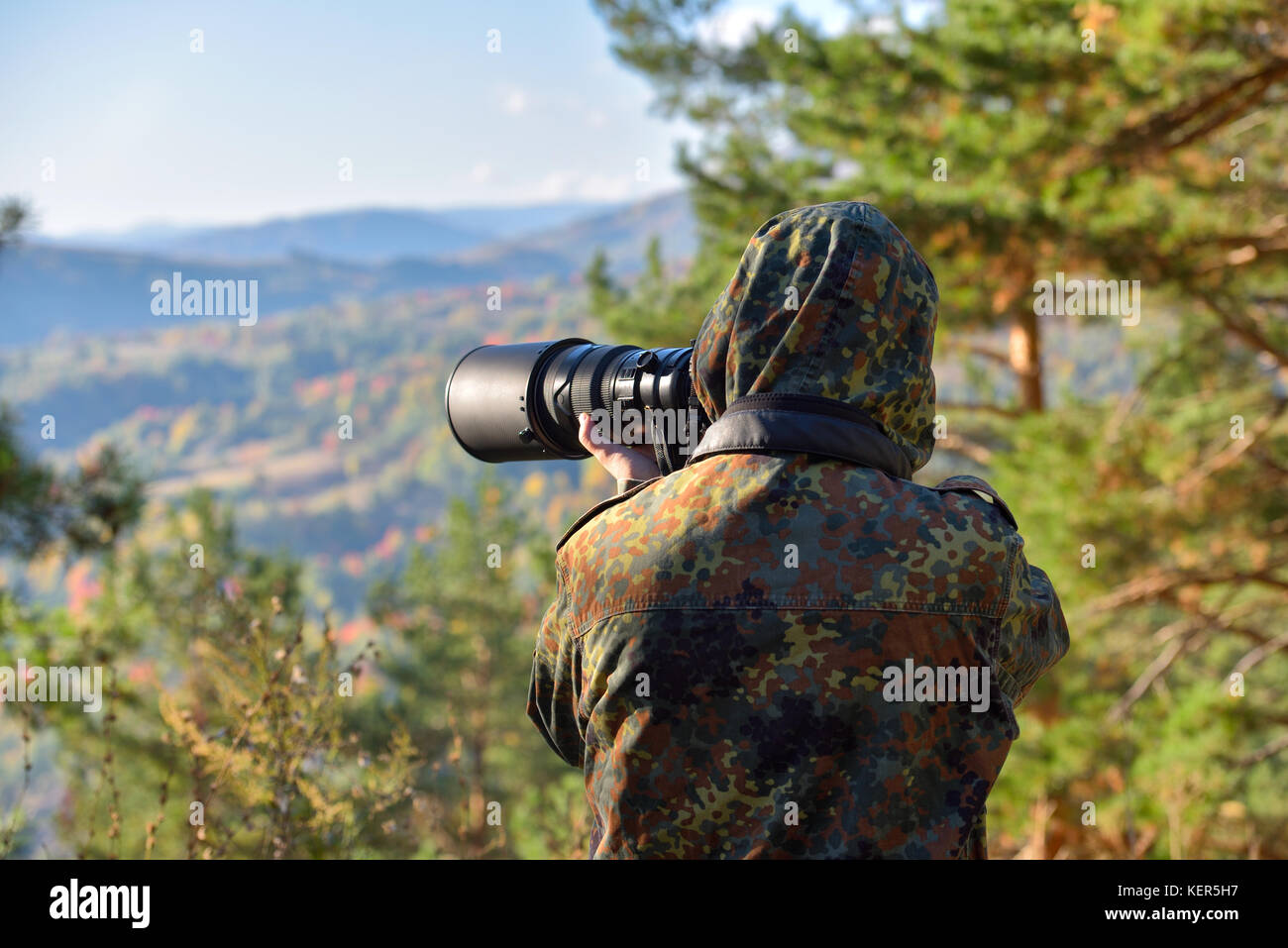Wildlife nature man photographer in camouflage outfit shooting taking