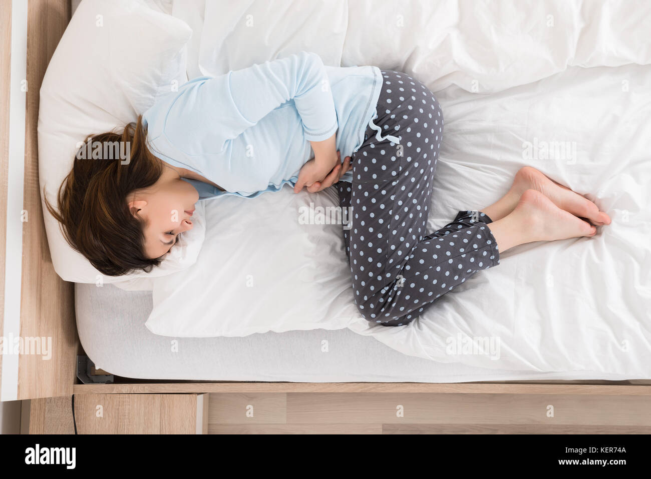 Young Woman With Stomach Ache Lying On Bed Stock Photo Alamy