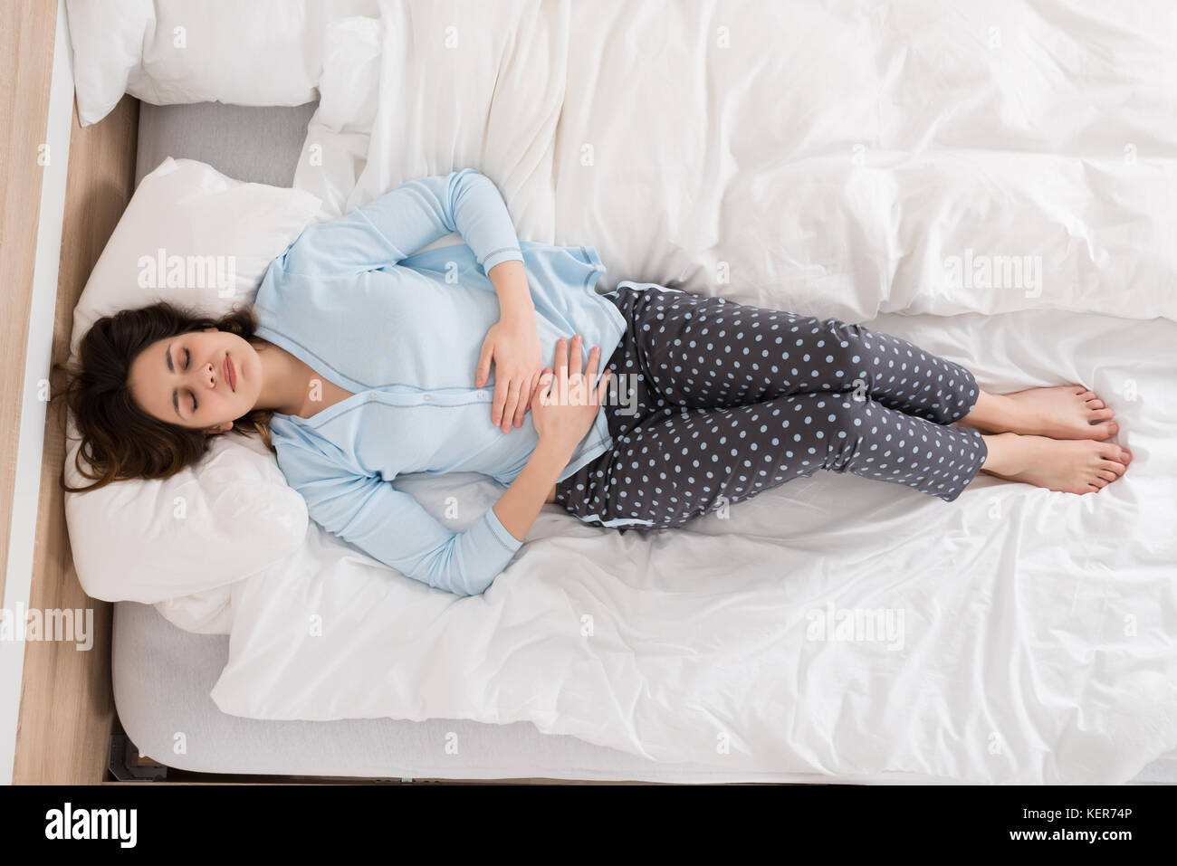 Young Woman With Stomach Ache Lying On Bed Stock Photo Alamy