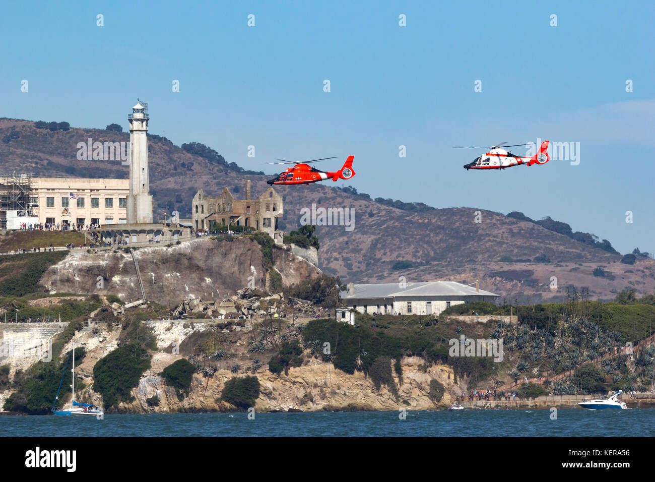 A pair of Coast Guard MH-65 Dolphin helicopters from Air Station San Francisco fly near Alcatraz on San Francisco Bay. Stock Photo