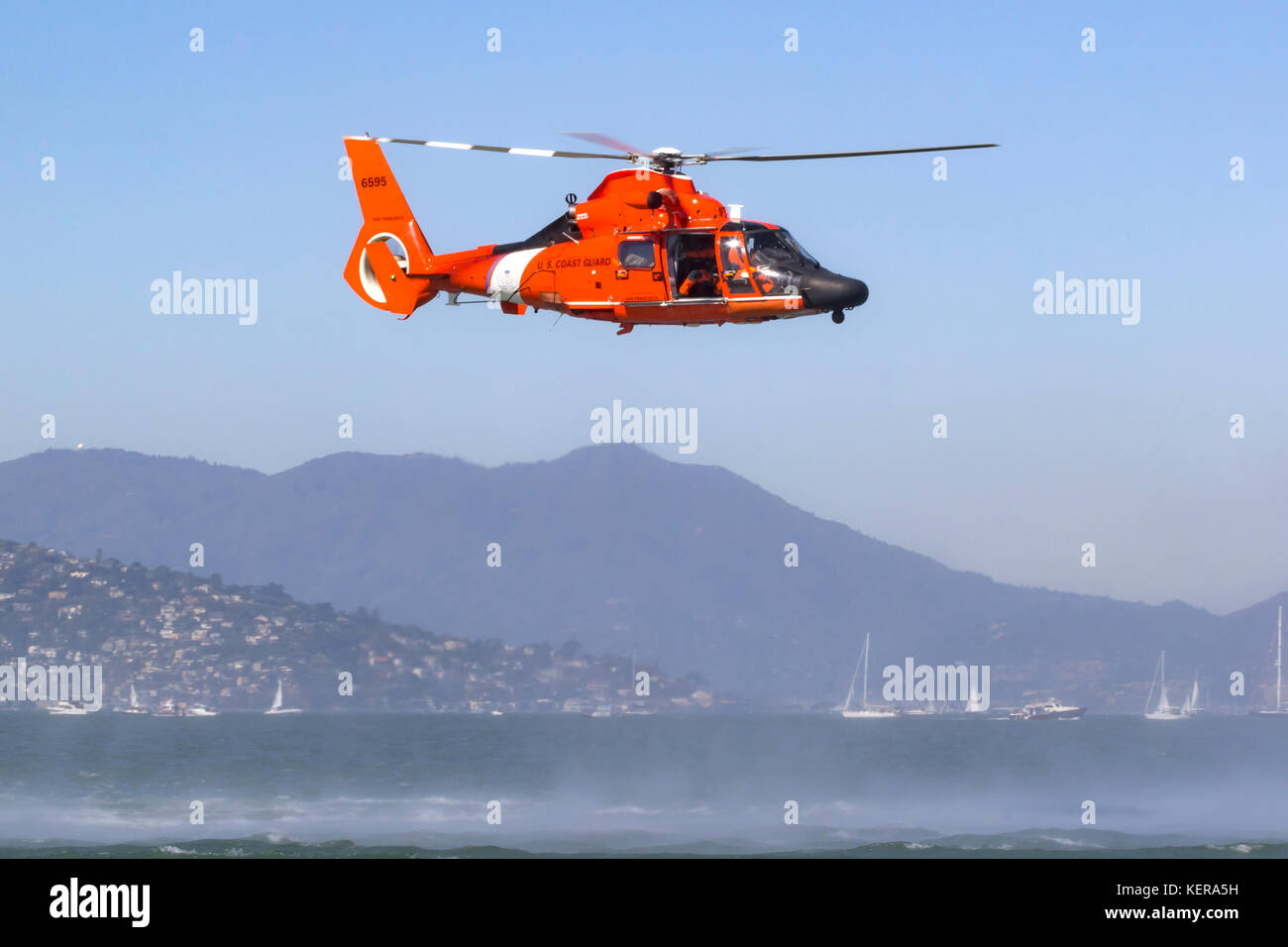 Coast Guard MH-65 Dolphin helicopter from Air Station San Francisco hovers over San Francisco Bay. Stock Photo