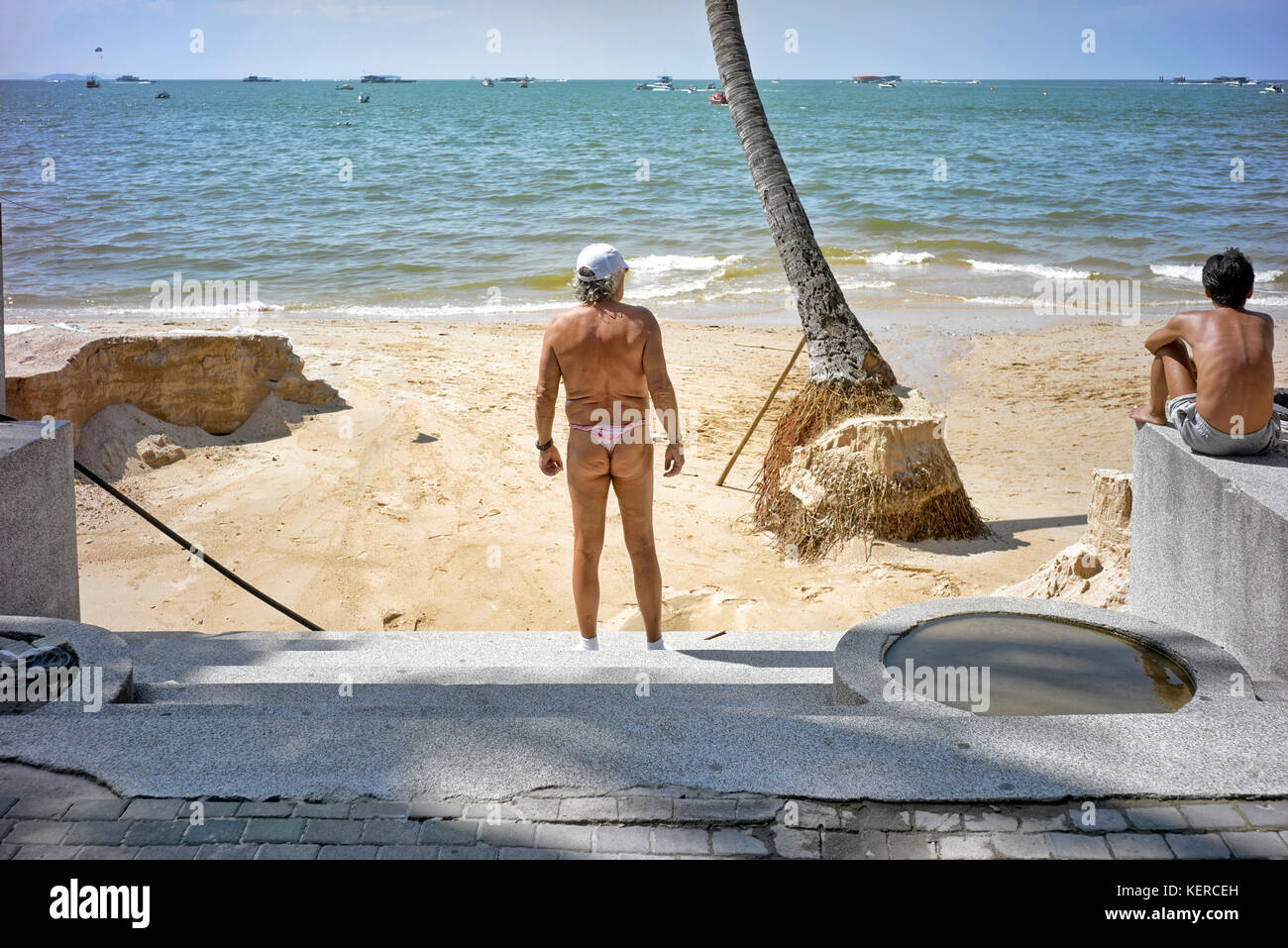 Man with rolled up swimming trunks sunbathing at Pattaya beach, Thailand, Southeast Asia. Stock Photo