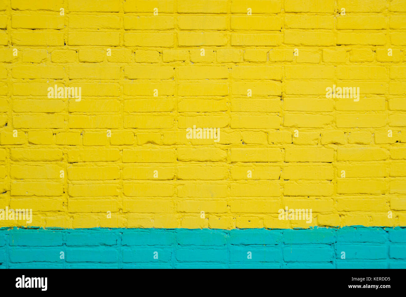 brick wall painted wit yellow-cyan color. saturated color. Stock Photo