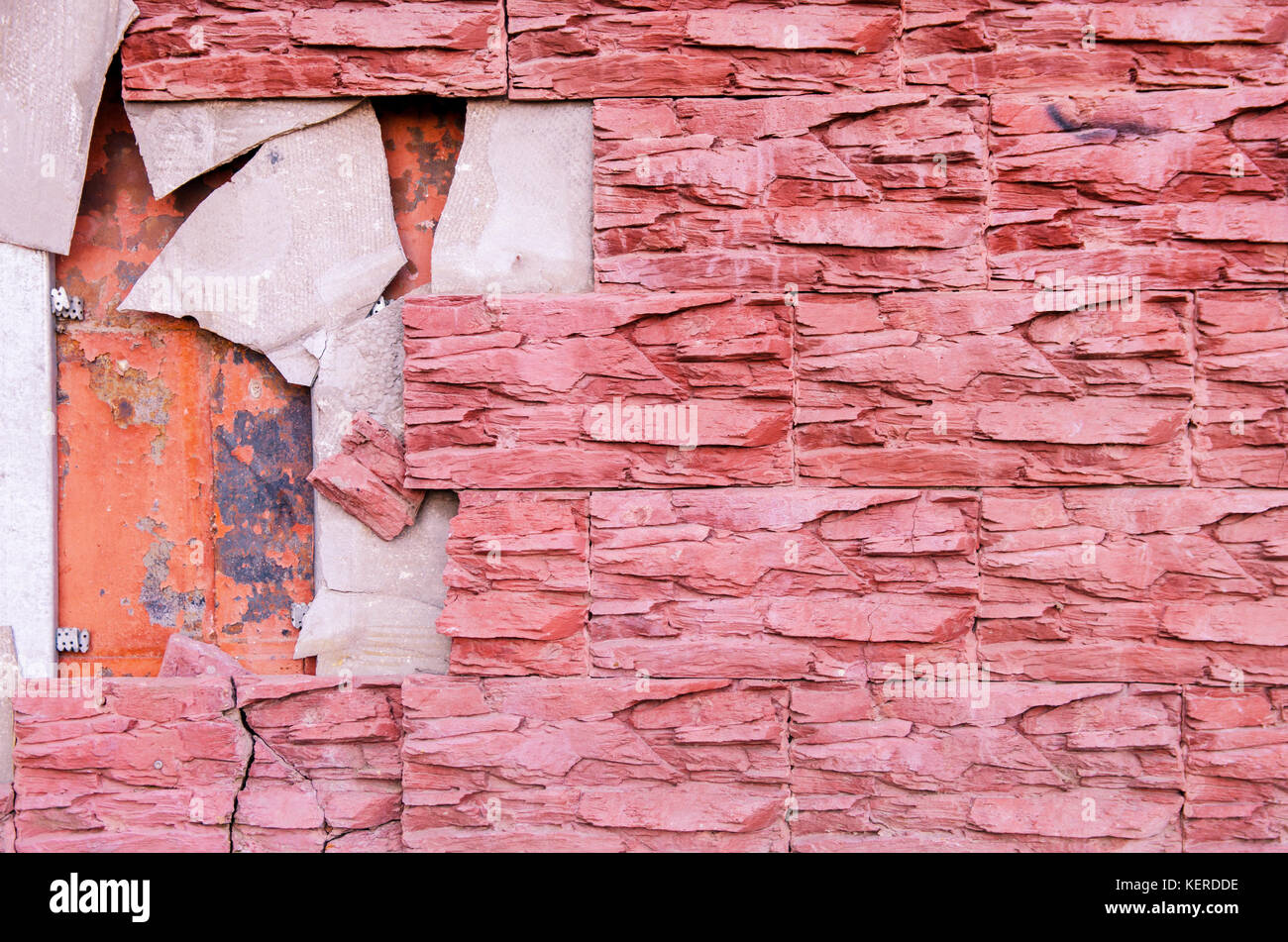 The broken tile on the tiled wall of the building requires repair. toned. Stock Photo