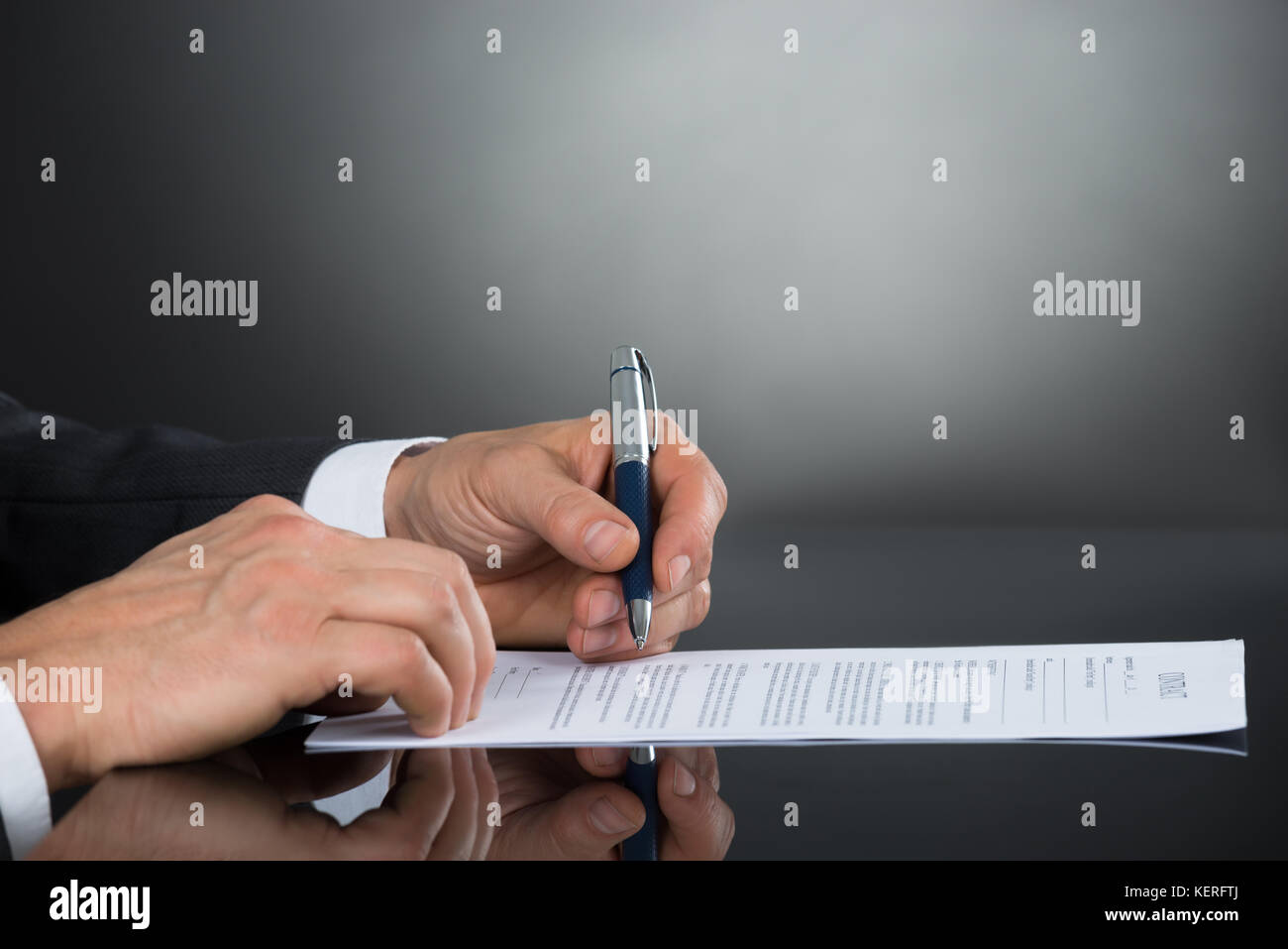Close-up Of Businessperson Hand Signing Contract Paper With Pen At Desk ...