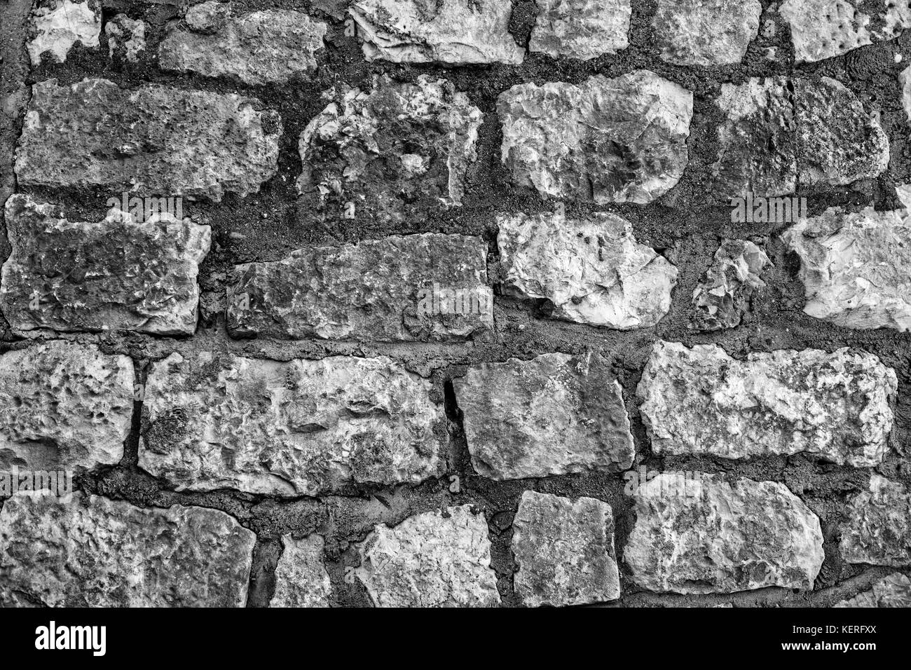 Wall made of stones of different shapes and sizes. Background Stock Photo