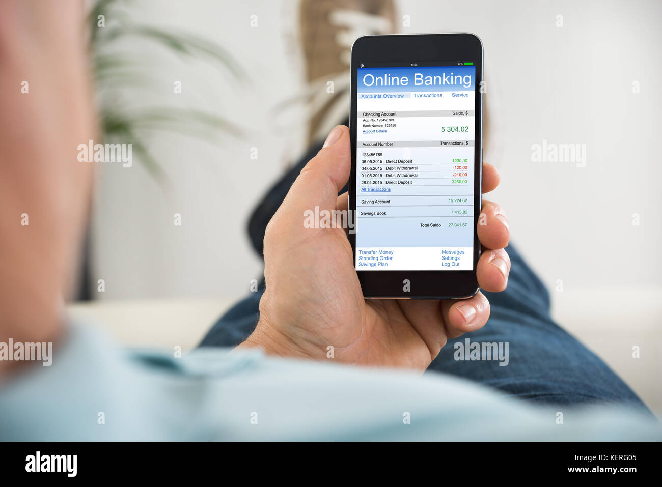 Close-up Of Person Hand Holding Mobile Phone Doing Online Banking Stock Photo