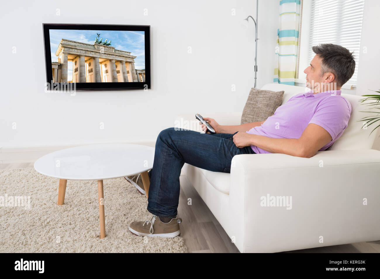 Mature Man Sitting On Couch Watching Television At Home Stock Photo Alamy
