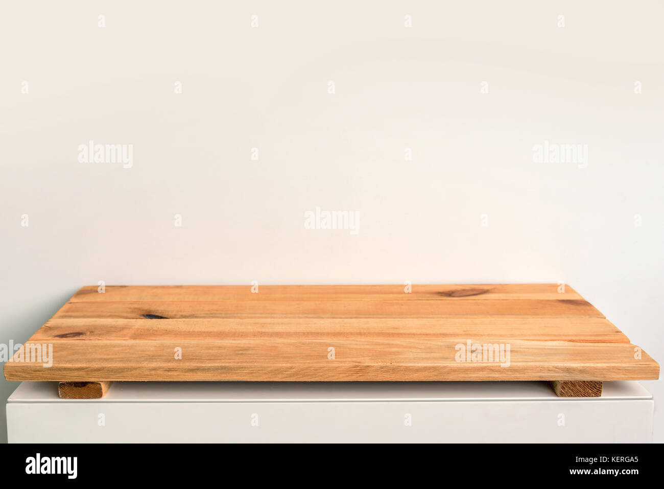 Empty wooden shelf on a white wall, backdrop ready to use for display or montage of your products Stock Photo