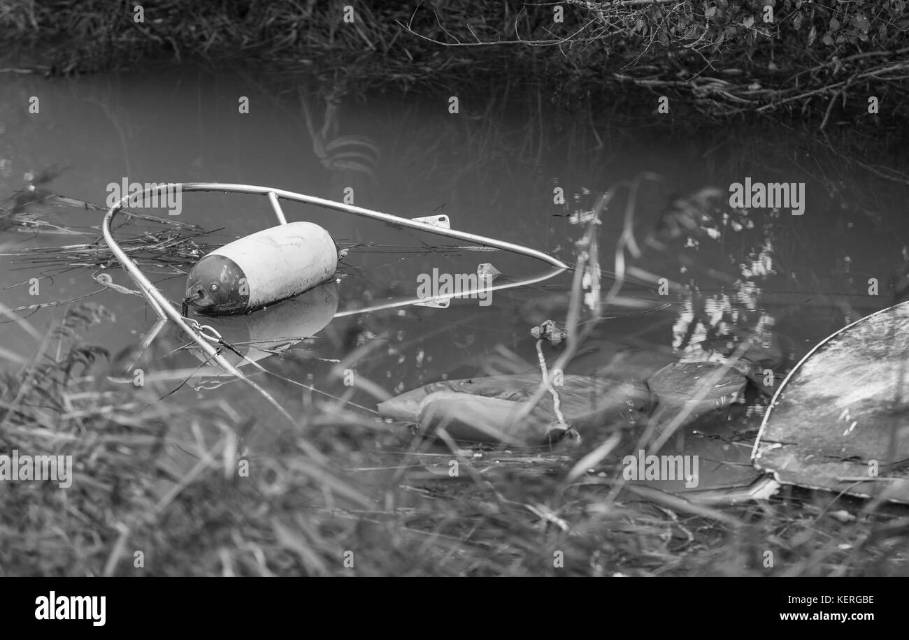 Small boat submerged in shallow water in a river in the UK. Stock Photo