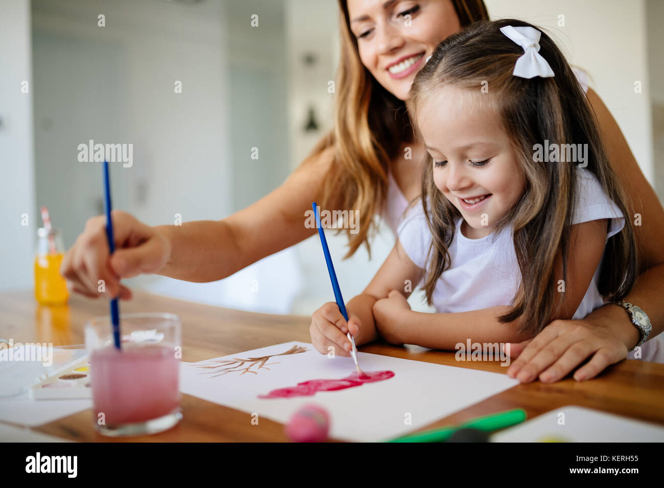 Little girl painting with her mother at home Stock Photo