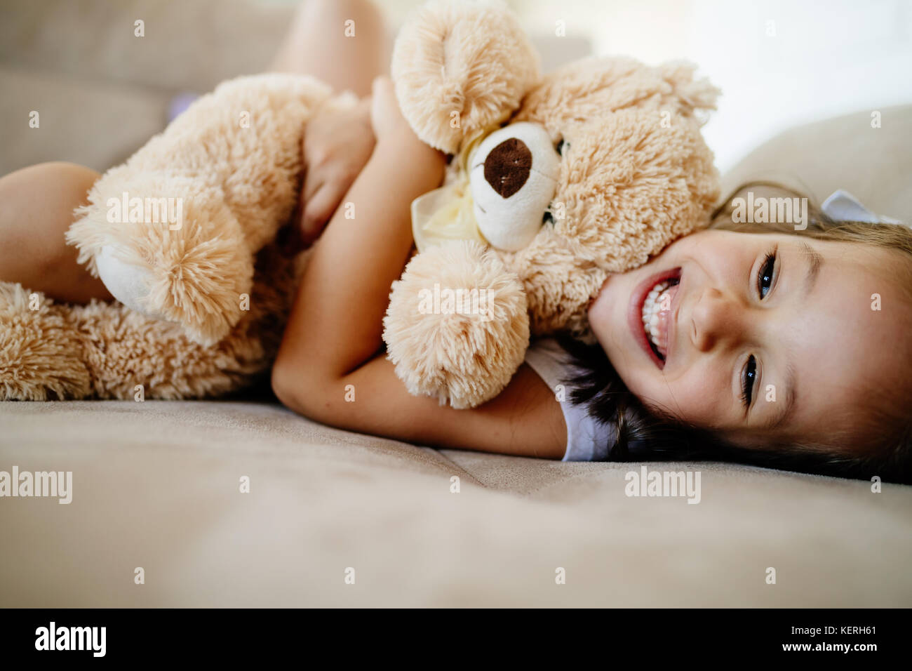 Cute little girl playing with teddy bear Stock Photo