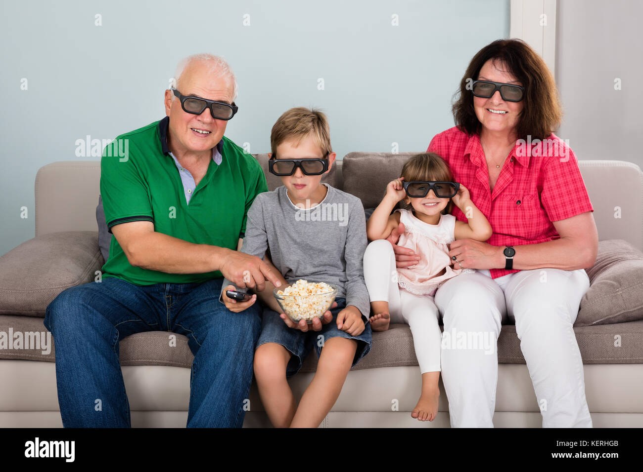 Family Entertaining Watching 3D TV At Home With Kids Stock Photo