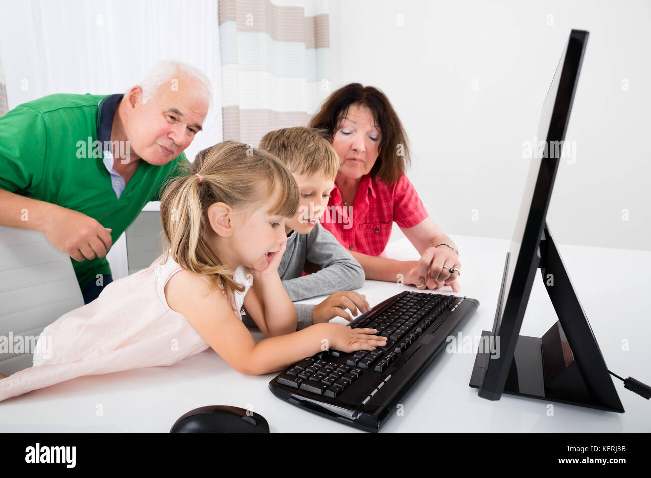 Happy Family Using Laptop Computer With Kids At Home Stock Photo - Alamy