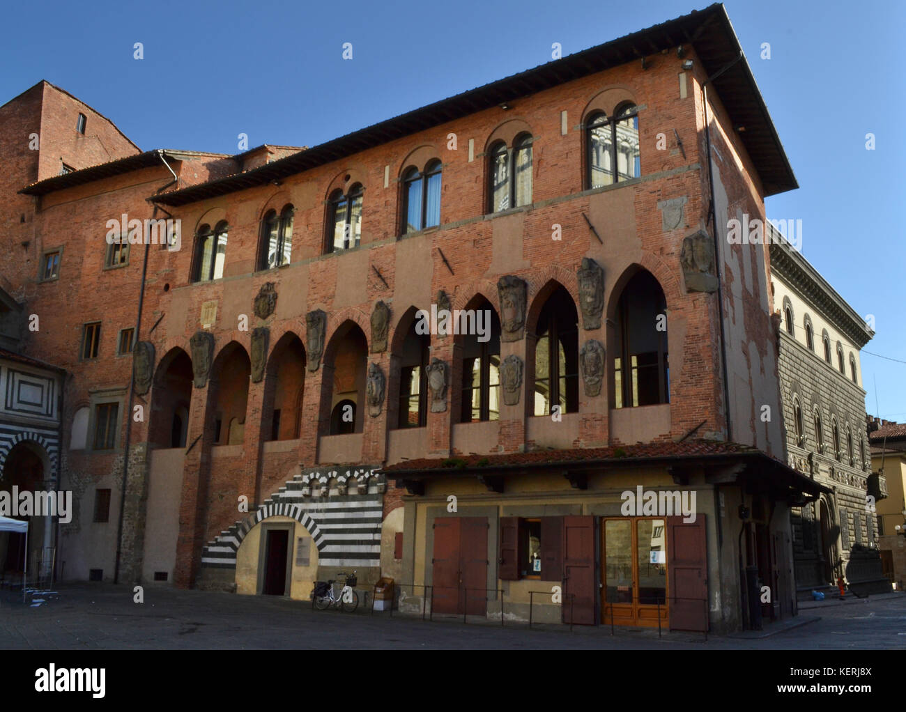Medieval facade of Palazzo dei Vescovi in Pistoia, with typical Italian loggia and gothic pointed arches. Stock Photo
