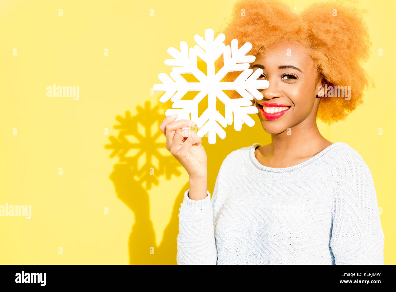 Snowflake Woman Portrait of a woman with artificial snowflake on the yellow background ...