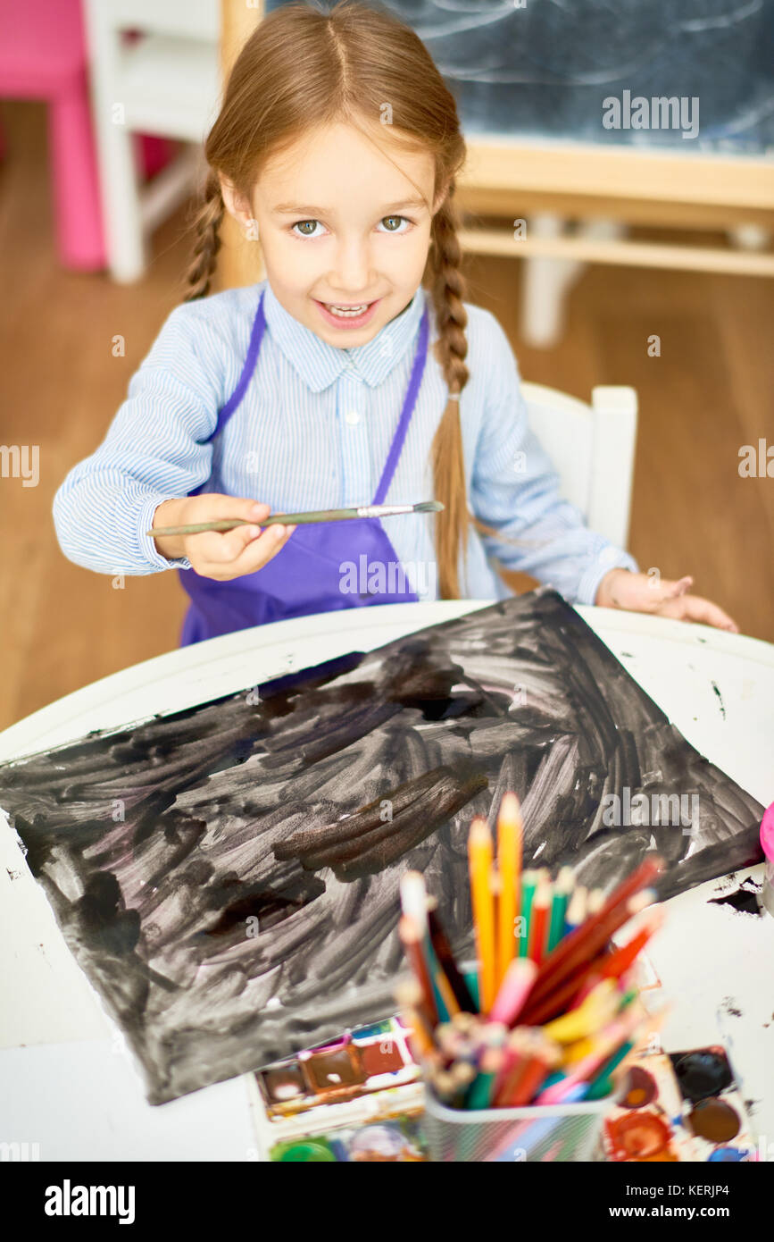 Cute Girl Painting Halloween Pictures in Art Class Stock Photo