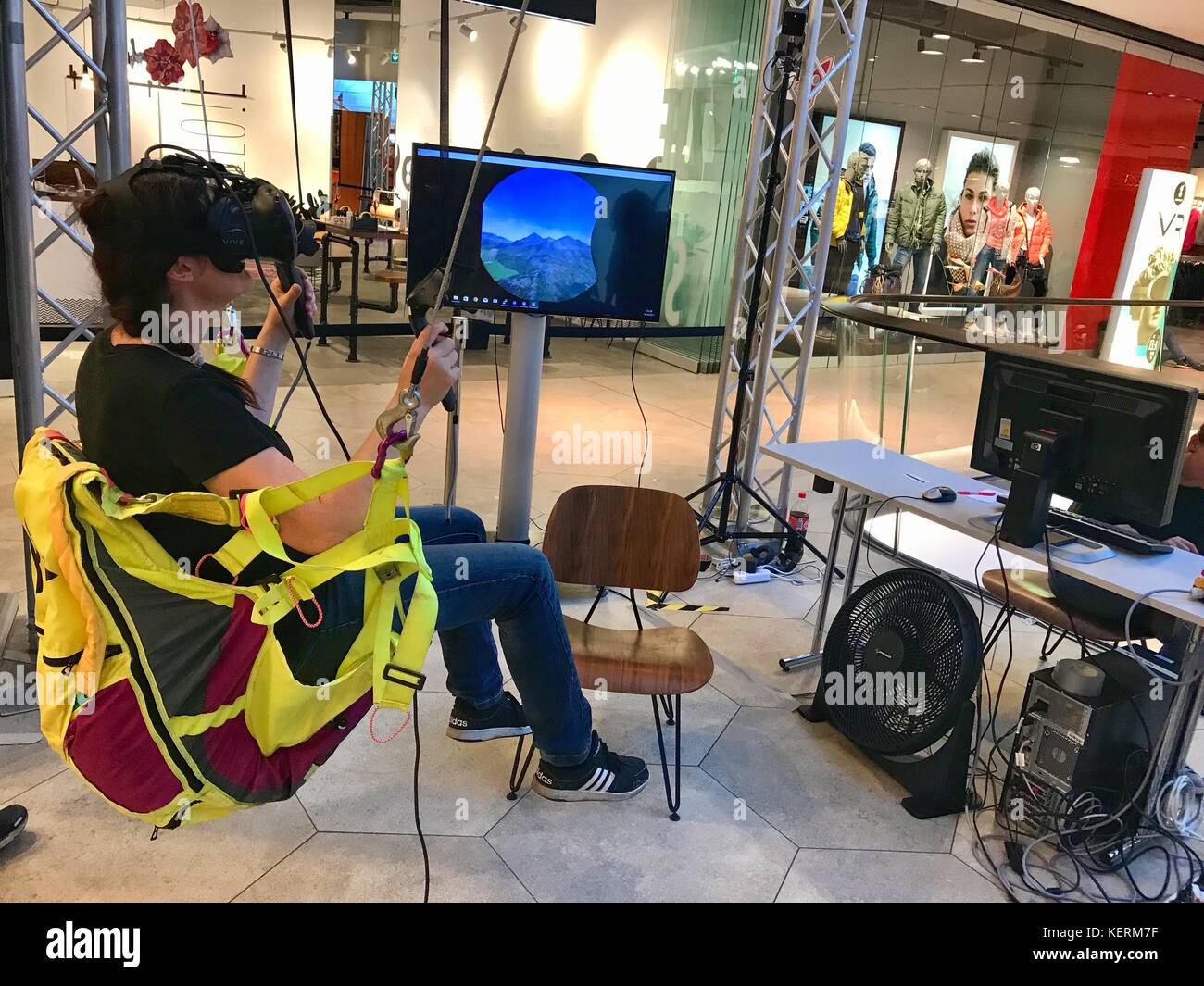 A girl is wearing virtual reality goggles in a shopping mall Stock