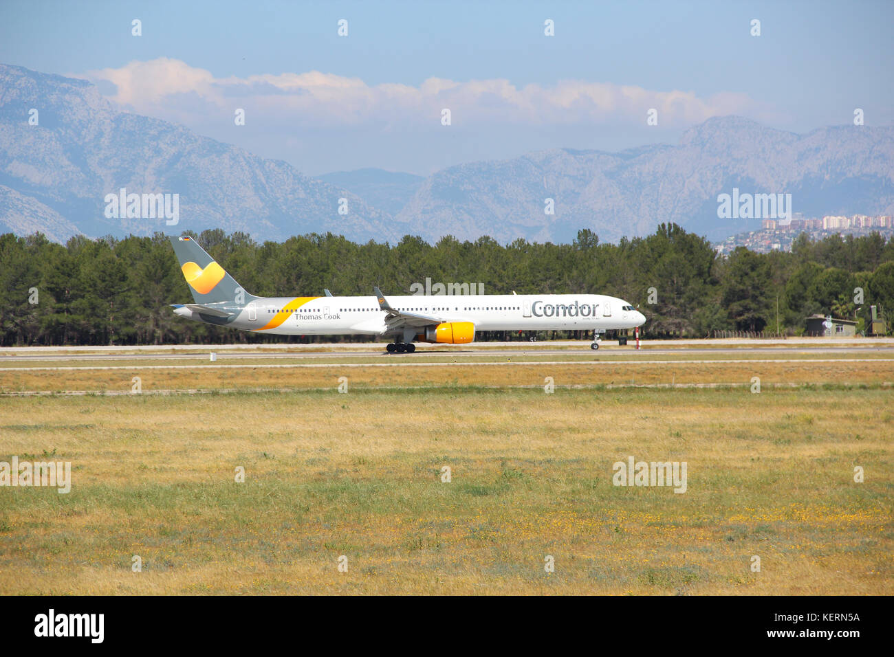 The Boeing 757-300 company Concord Thomas cook takes off at the airport, amid the fields, forests and mountains, spring-summer, Sunny weather Stock Photo