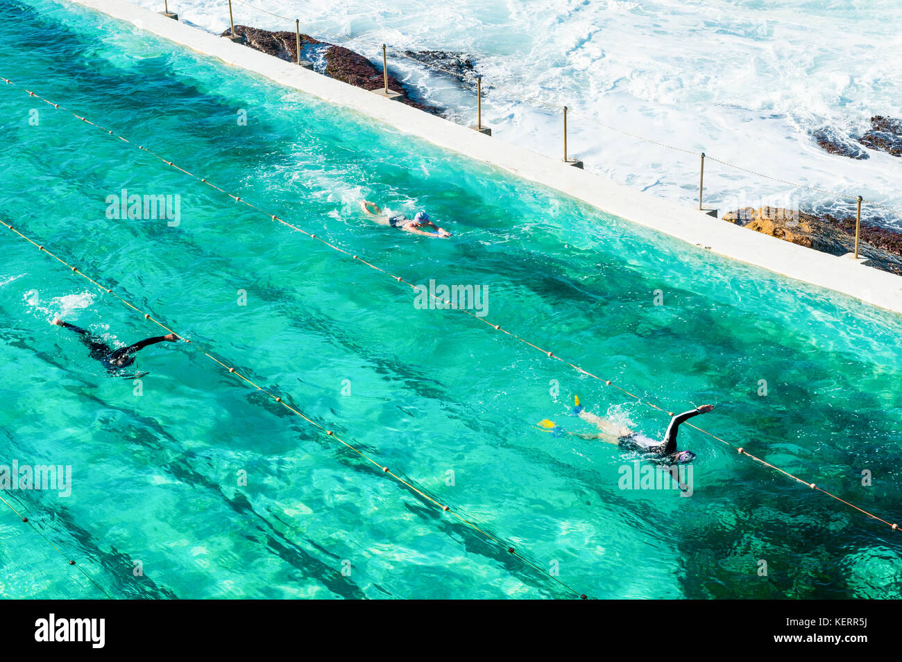 Swimmers enjoy the crystal clear waters of the outdoor pool and sea water around Bondi beach and the coastal walk from Coogee to Bondi in Sydney Austr Stock Photo