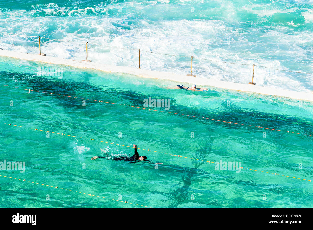 Swimmers enjoy the crystal clear waters of the outdoor pool and sea water around Bondi beach and the coastal walk from Coogee to Bondi in Sydney Austr Stock Photo