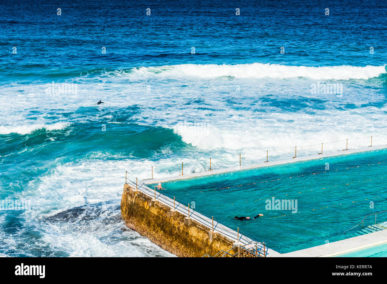 Swimmers enjoy the crystal clear waters of the outdoor pool and sea water around Bondi beach and the coastal walk from Coogee to Bondi in Sydney Austr Stock Photo