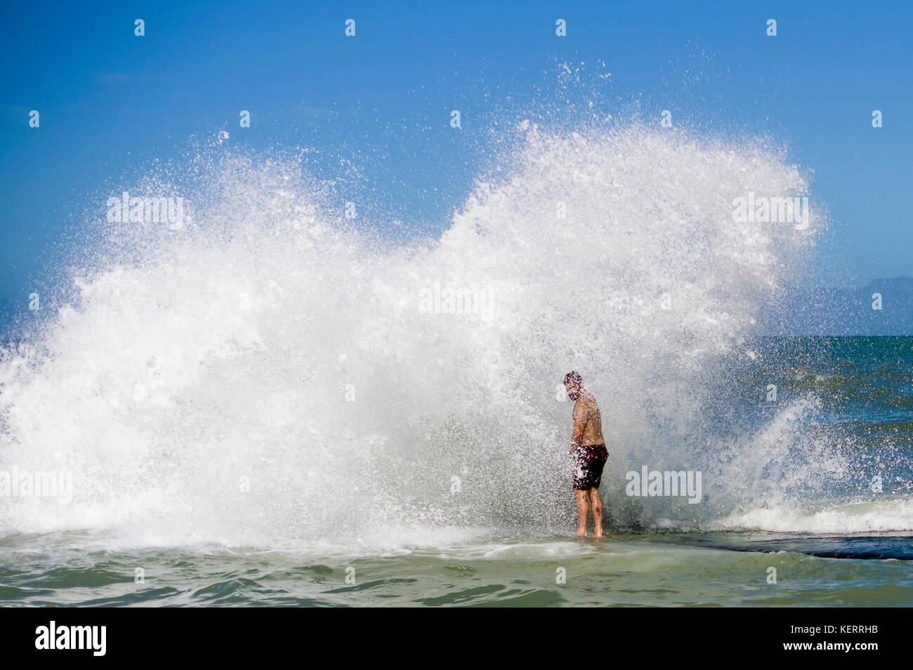 A swimmer is overcome by a wave on a tidal pool in Kalk Bay, False Bay, Cape Town, South Africa Stock Photo
