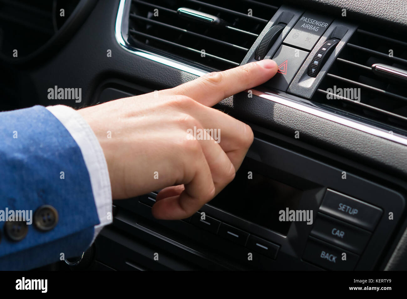 finger of a human hand presses the button of emergency lighting during driving, preventing the danger Stock Photo