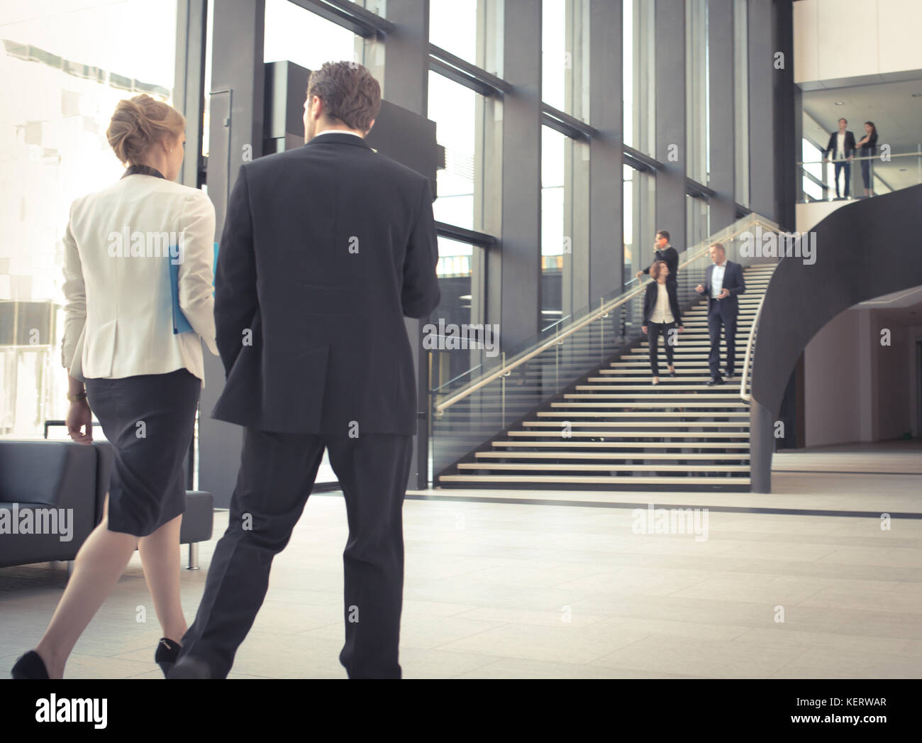 Modern business people walking in glass hall of office building Stock ...