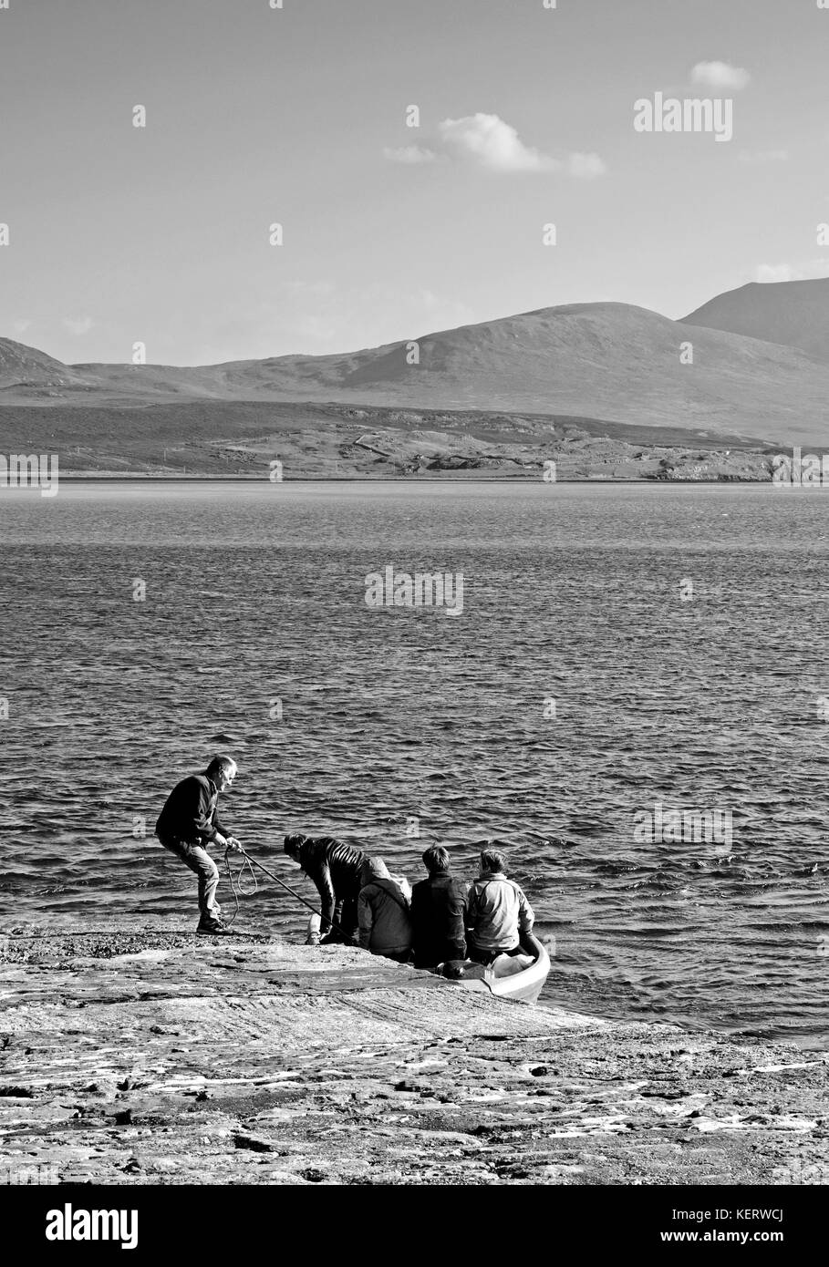 Cape Wrath ferry, Keoldale, Kyle of Durness, Sutherland. The ferryman holds the boat steady as passenger prepare to disembark from the small dinghy. Stock Photo