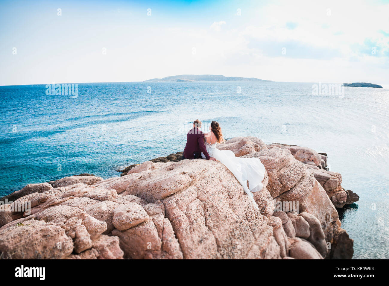 couple sitting on rock from the back Stock Photo