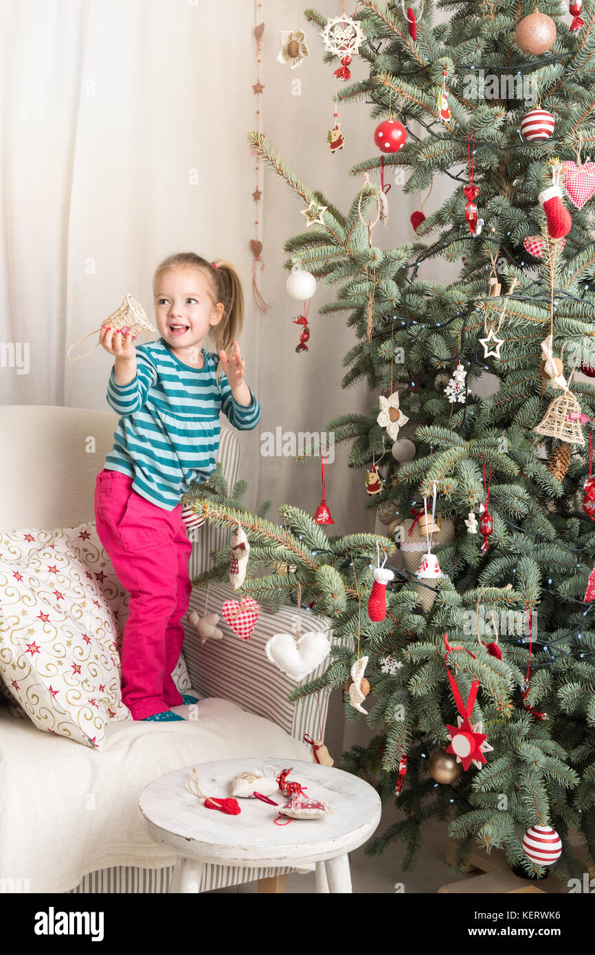 Child helping to decorate xmas tree Stock Photo