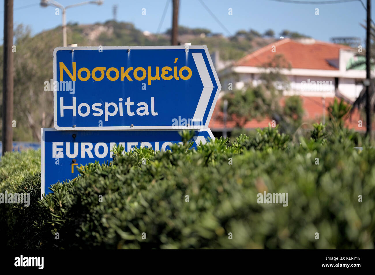 A road sign, on a main road, directing traffic to a local Greek hospital on the Greek island of Rhodes Stock Photo