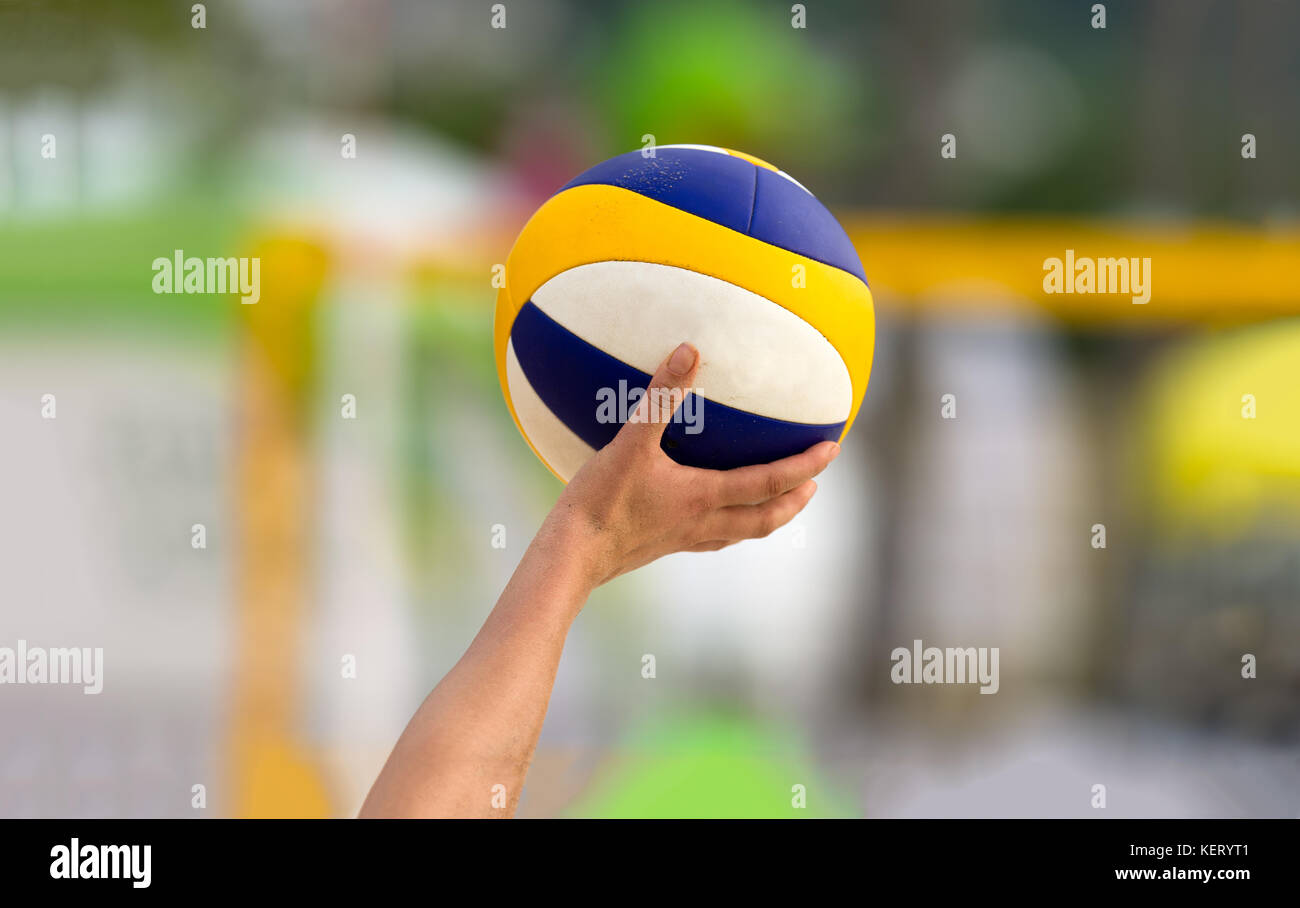 Volleyball is a volleyball player holding up a volleyball getting ready