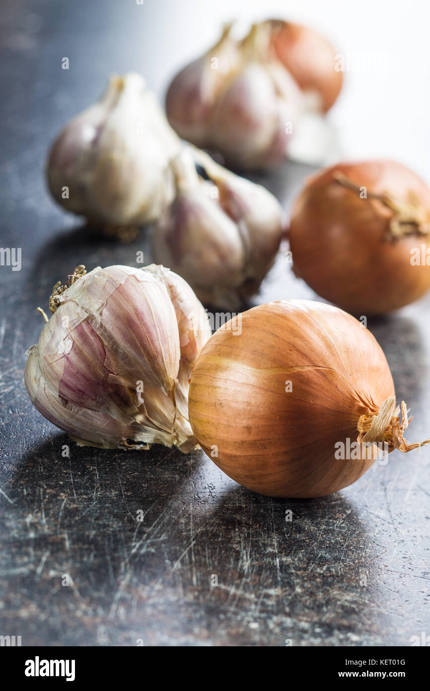 Fresh onion and garlic bulbs on old kitchen table Stock Photo Alamy