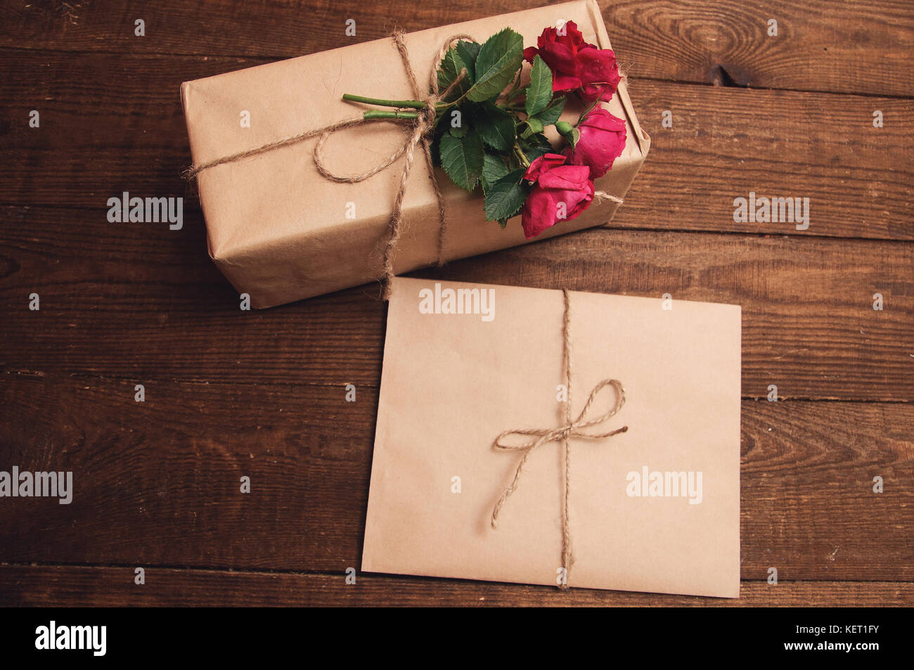 gift wrapped in kraft paper with rose flower at the top near the ...