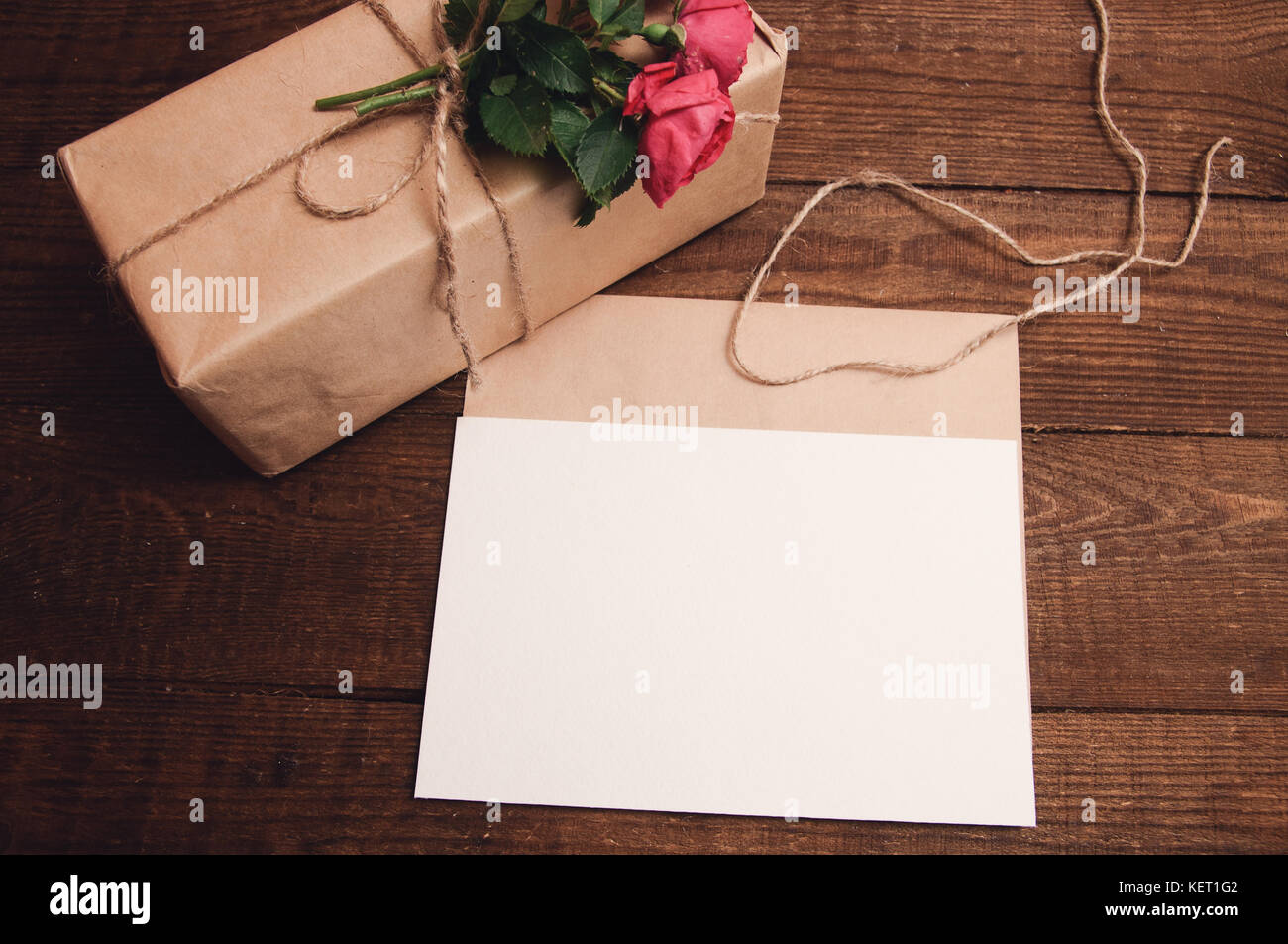 gift wrapped in kraft paper with rose flower at the top near the ...