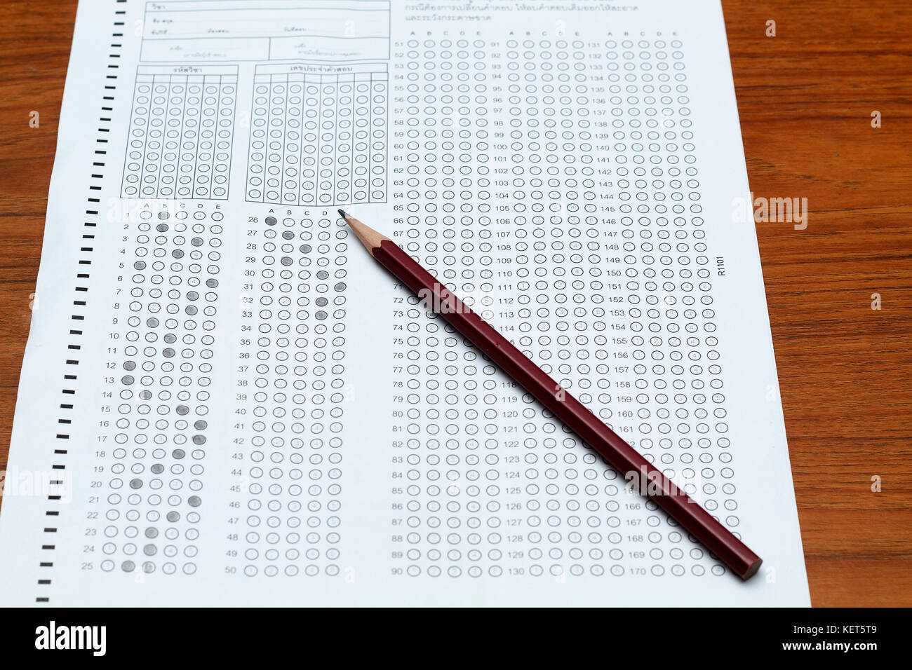 glasses and pencil on Standardized test form with answers bubbled in
