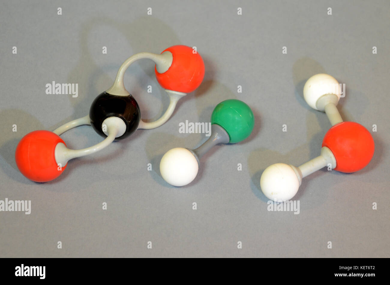 Molecule model of (left to right): Carbondioxide, hydrochloric gas, and water. Red is oxygen, black is carbon, green is chlorine, and white is hydroge Stock Photo