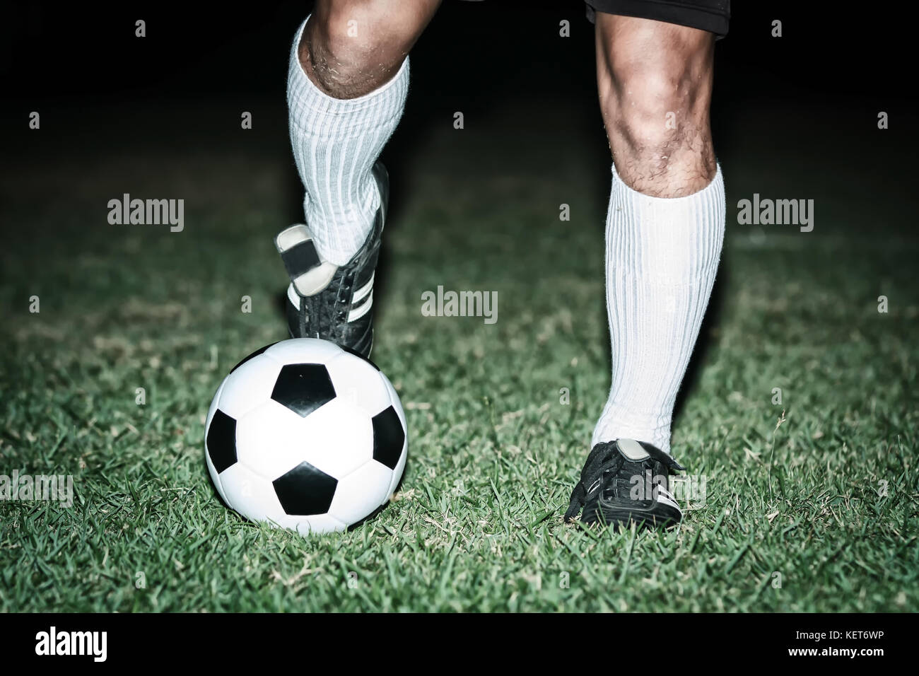Football player shoot a soccer ball with his feet on the football field
