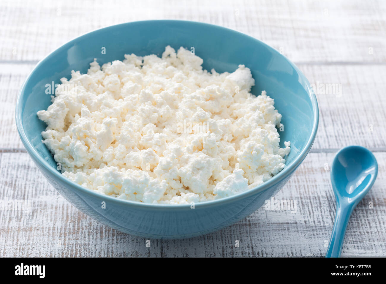 Organic Farmers cheese, Cottage cheese, Curd cheese, Tvorog or Ricotta cheese in a blue bowl