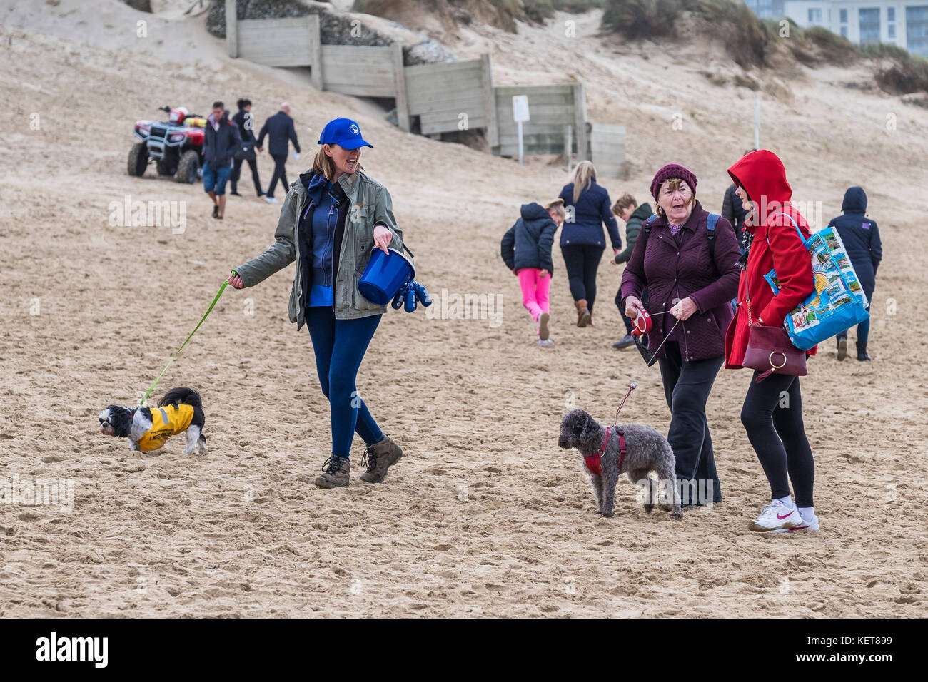 Dog walking - women walking their dogs on Fistral Beach Newquay. Stock Photo