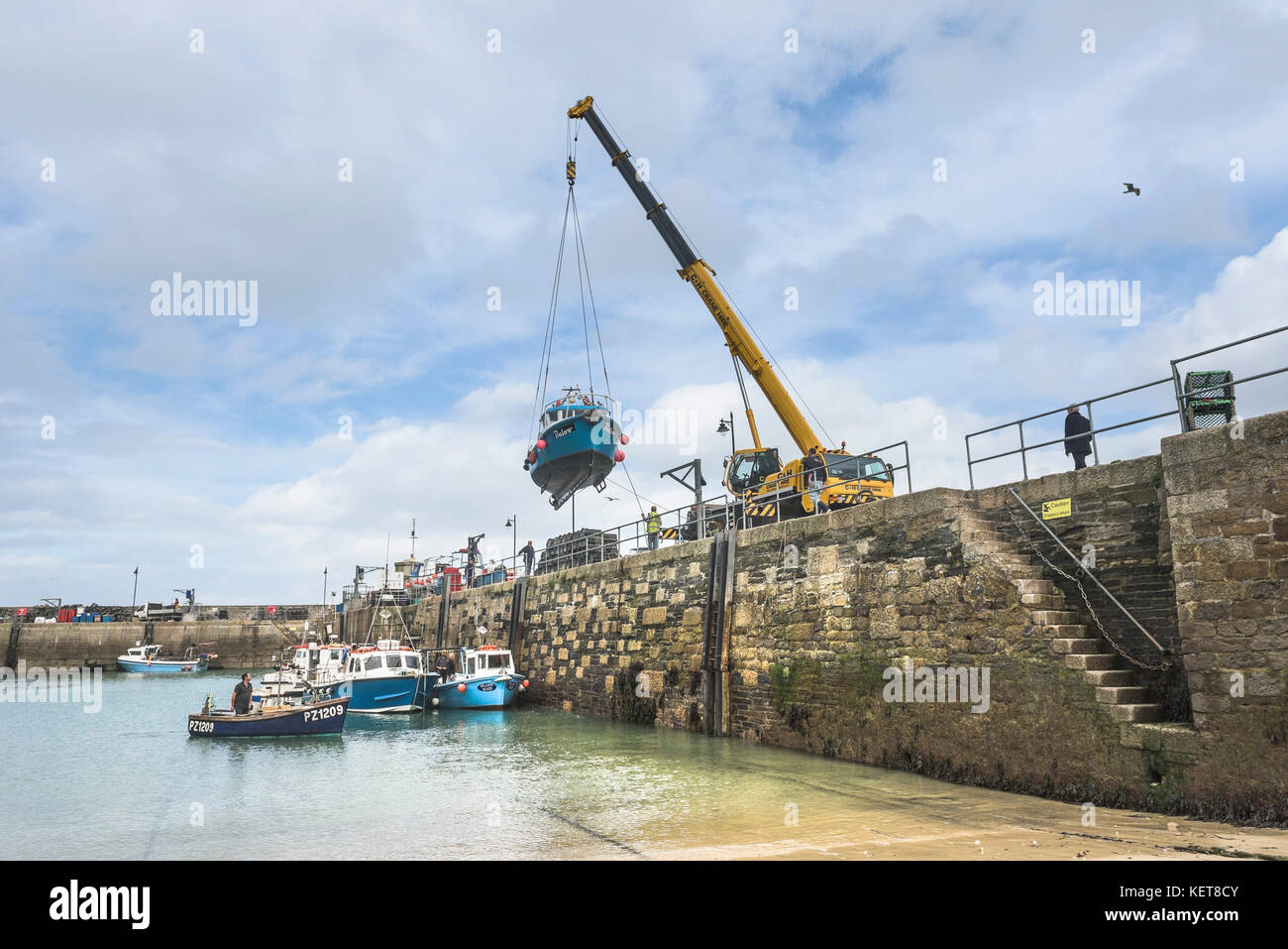 Newquay Harbour Cornwall - a boat being craned out of Newquay harbour for Winter storage. Stock Photo