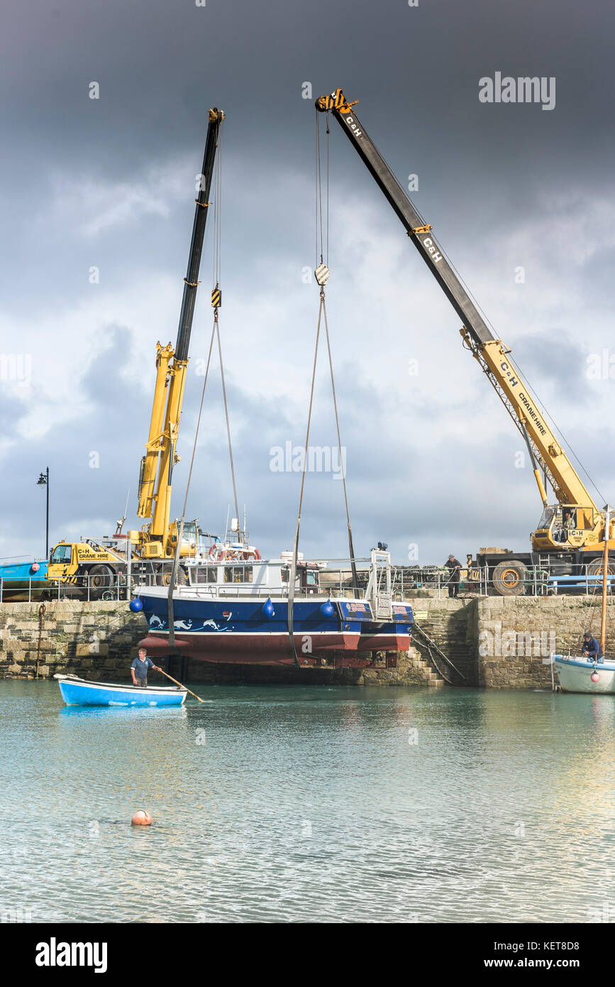 Newquay Harbour Cornwall - a boat being craned out of Newquay harbour for Winter storage. Stock Photo
