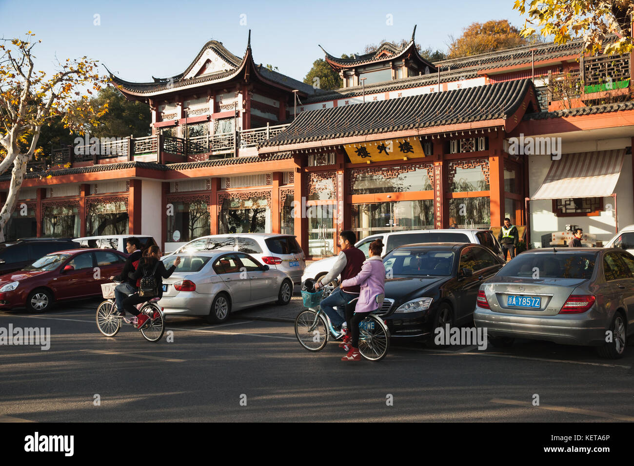 Hangzhou, China - December 5, 2014: Young bicycle riders are on the coastal road of West Lake, popular park in Hangzhou city center, China Stock Photo