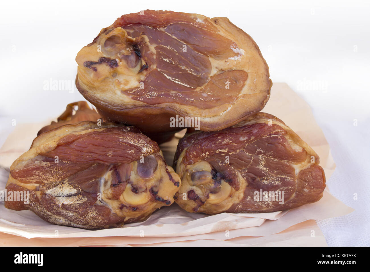 Three Smoked ham hock on paper in butcher shop Stock Photo