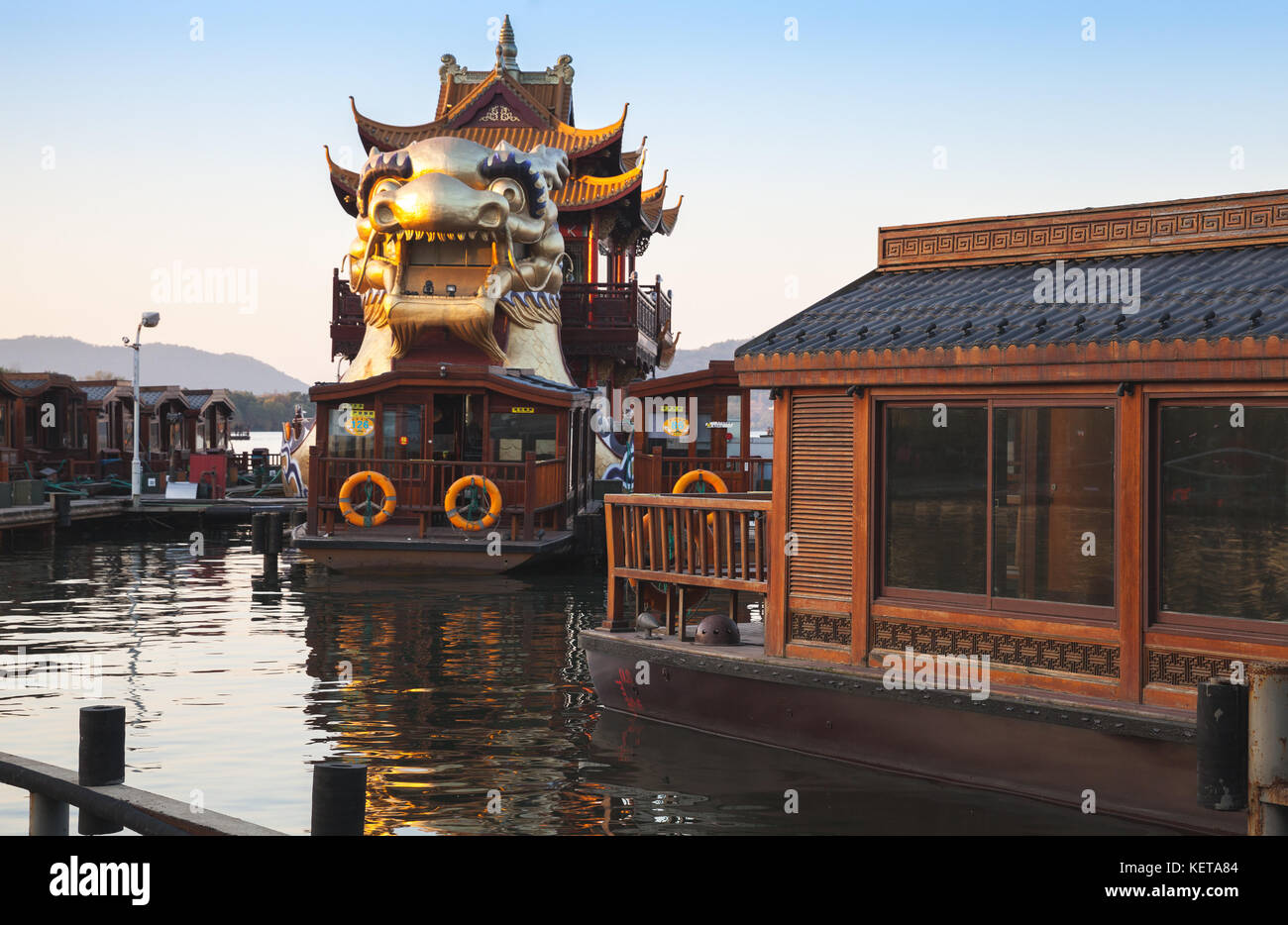 Hangzhou, China - December 5, 2014: Chinese wooden recreation boats and Dragon ship are moored on the West Lake. Famous park in Hangzhou, China Stock Photo